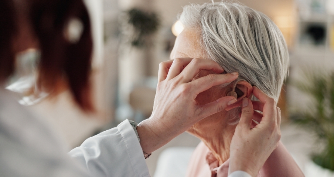dame krijgt een hoorapparaat ingebracht