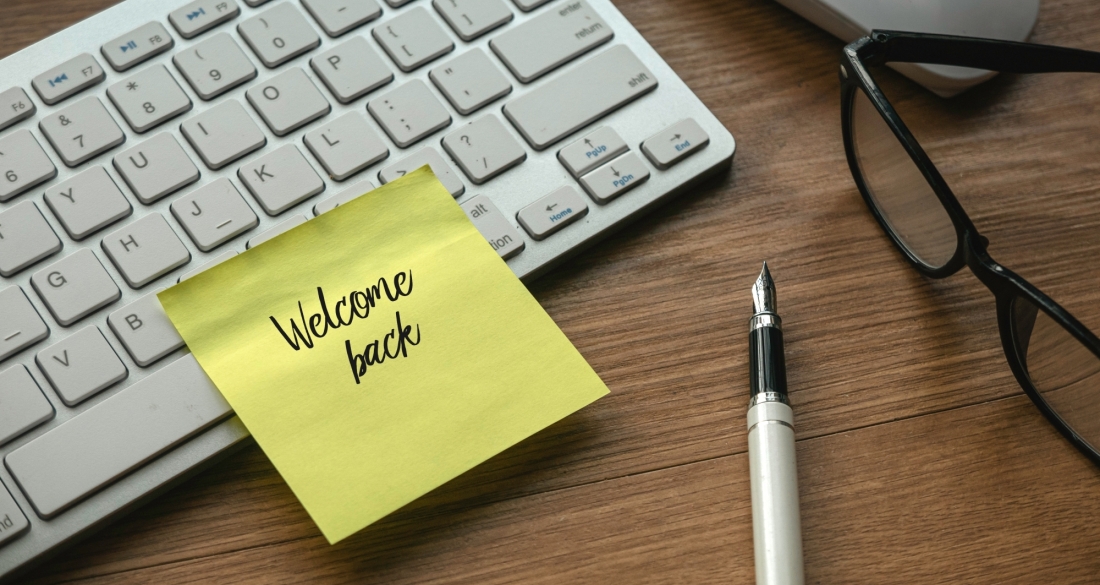 werkplek met post it waarop 'welcome back' staat