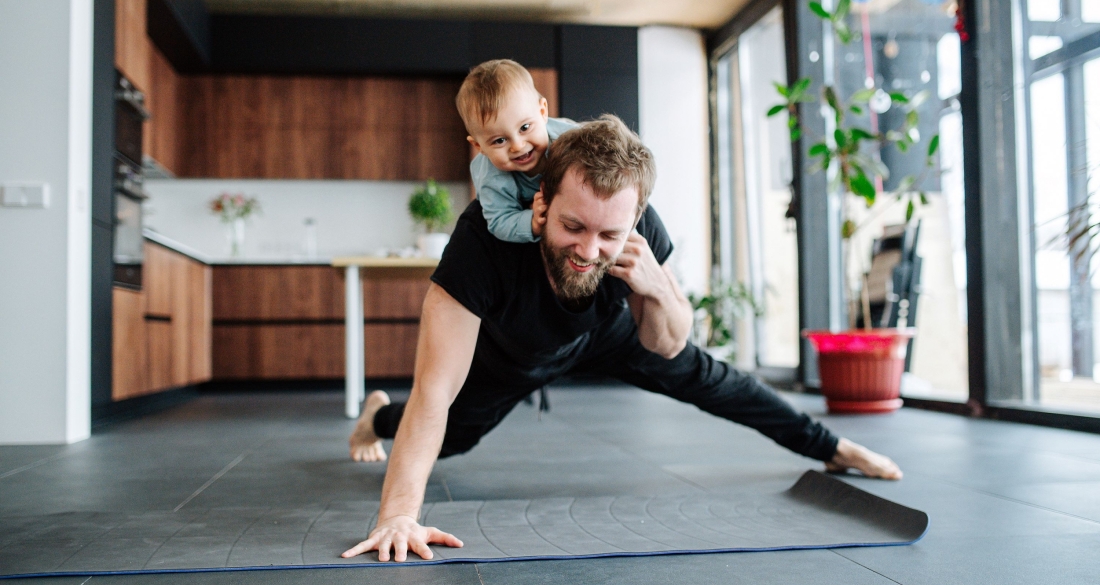 papa met kind aan het sporten binnenshuis