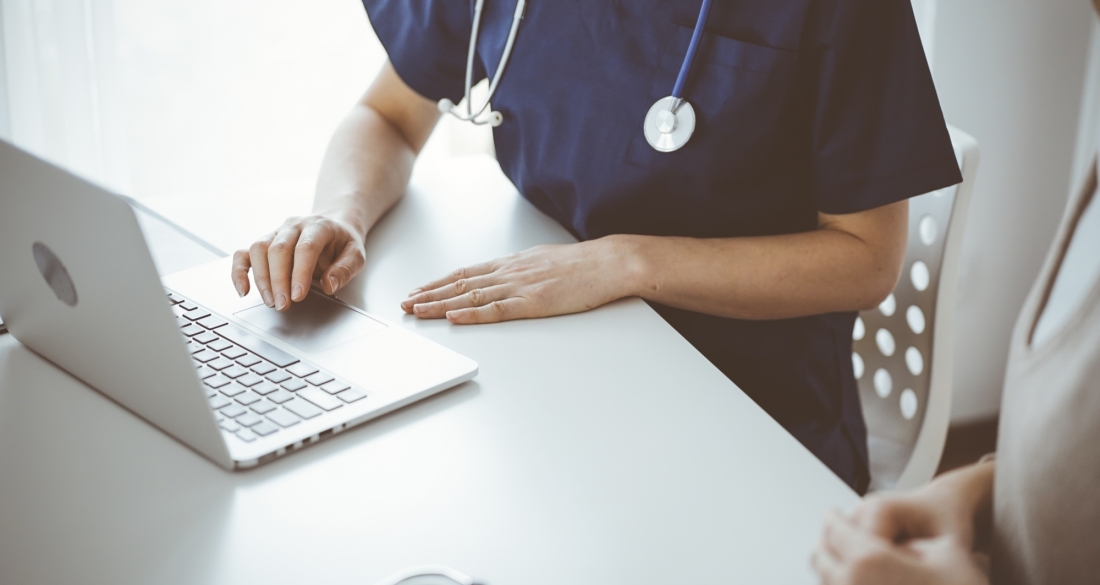 Dokter met patiënt aan computer