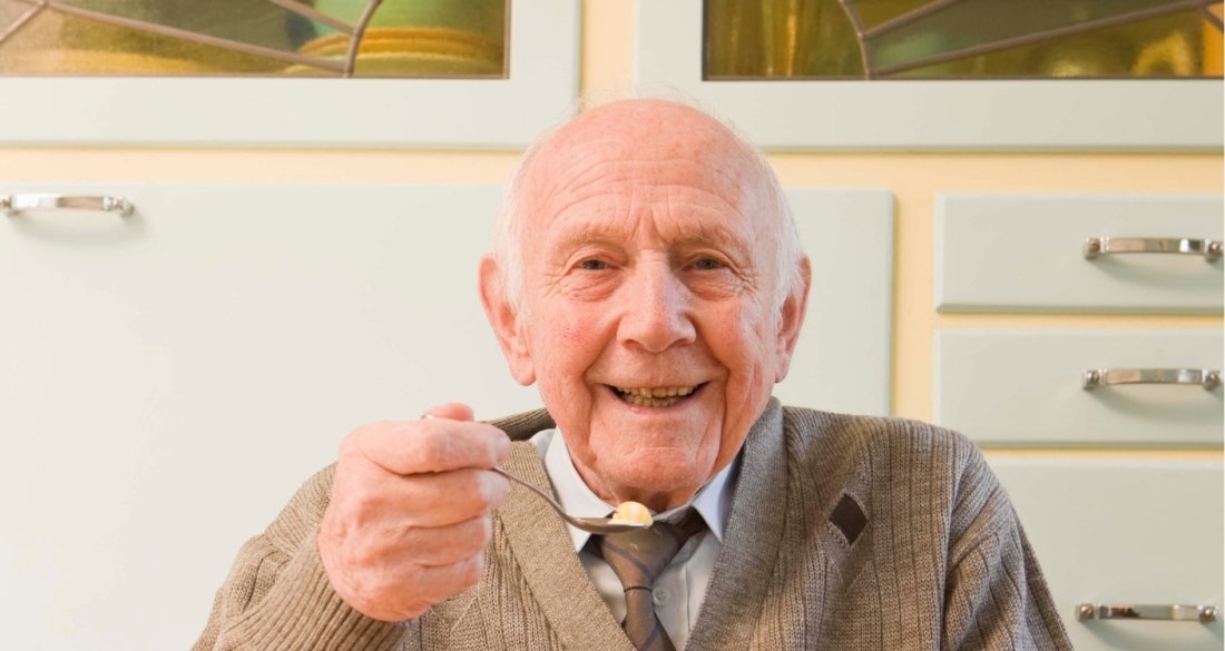 oude man met eten op zijn lepel