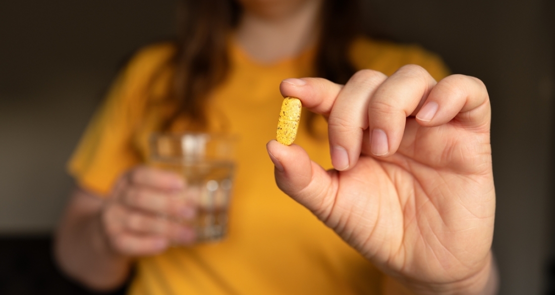 vrouw met pil en glas water