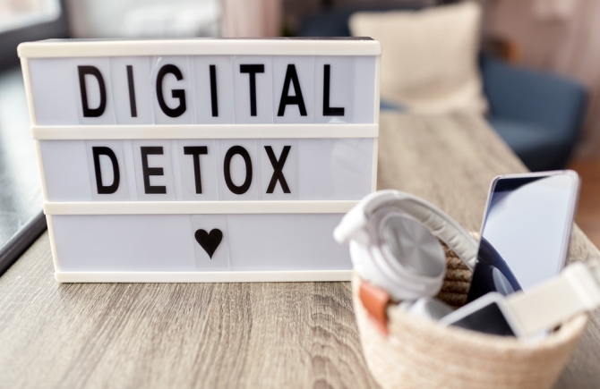 digital detox bord met een mandje met allemaal elektronica in